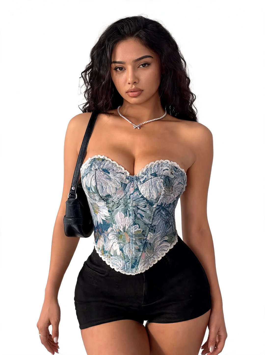 Model wearing a blue floral lace-trimmed corset top and black shorts from the VELOUR tops collection